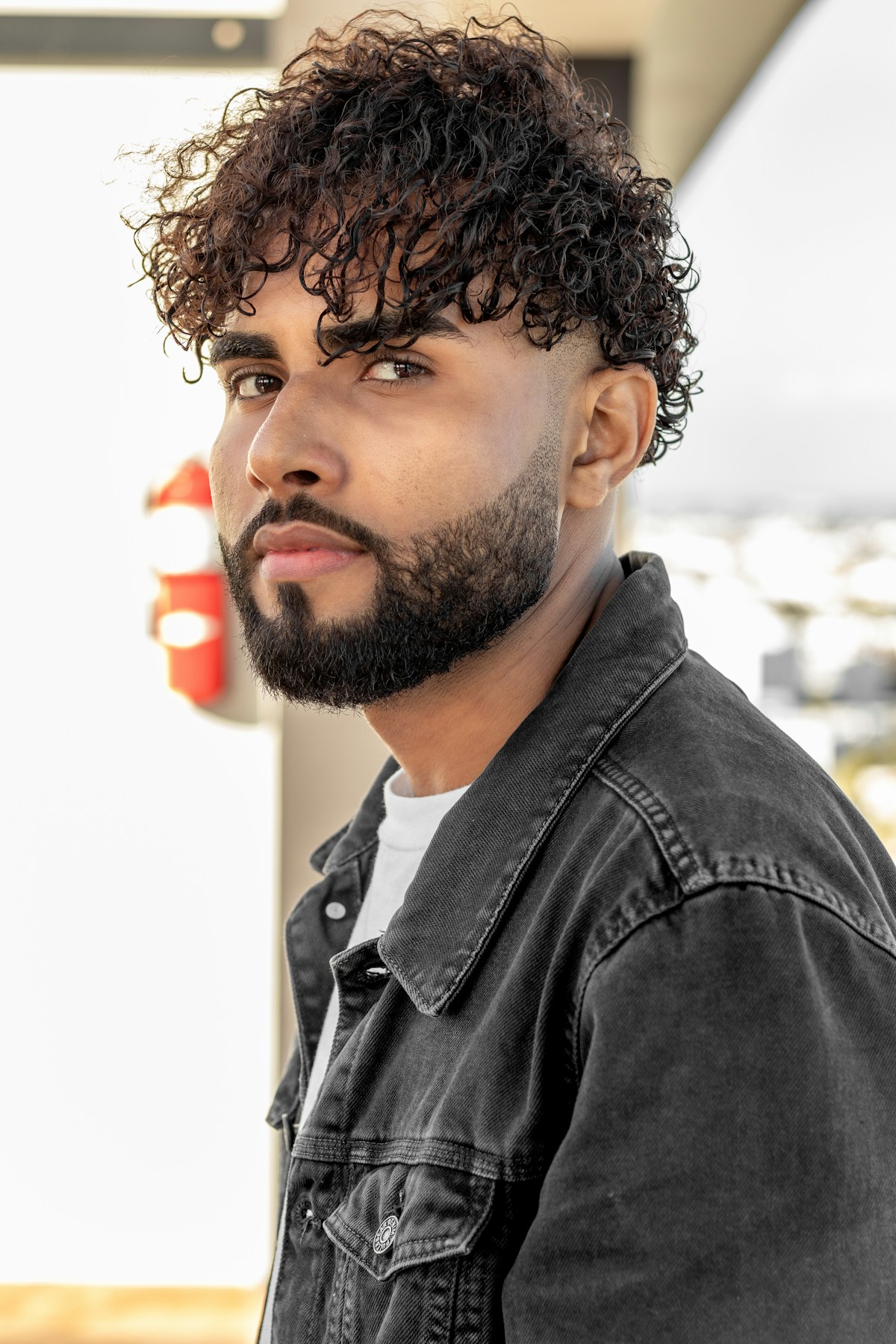 Barbe taillée et cheveux bouclés