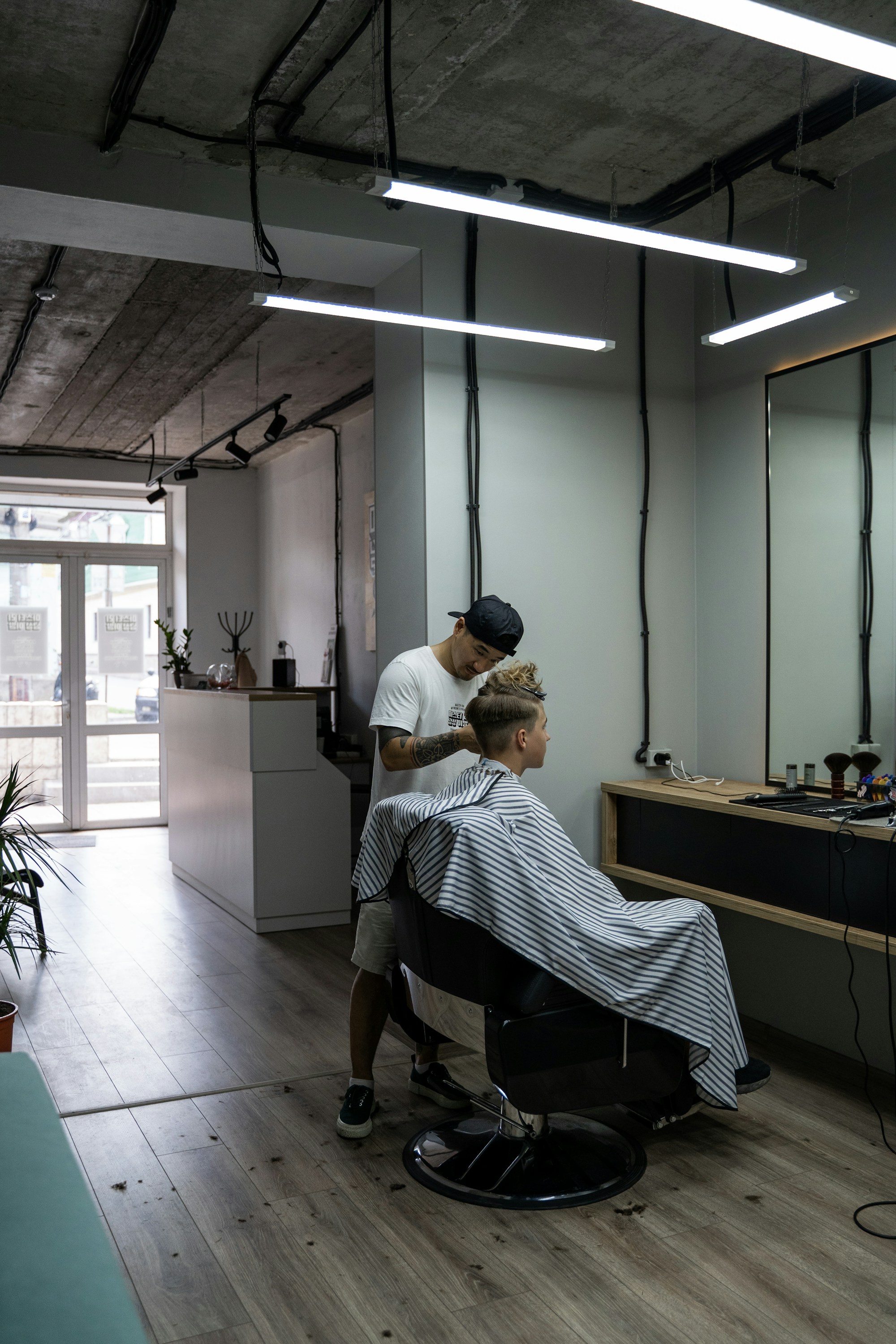 Un barber réalise une coupe dans un salon clair et minimaliste