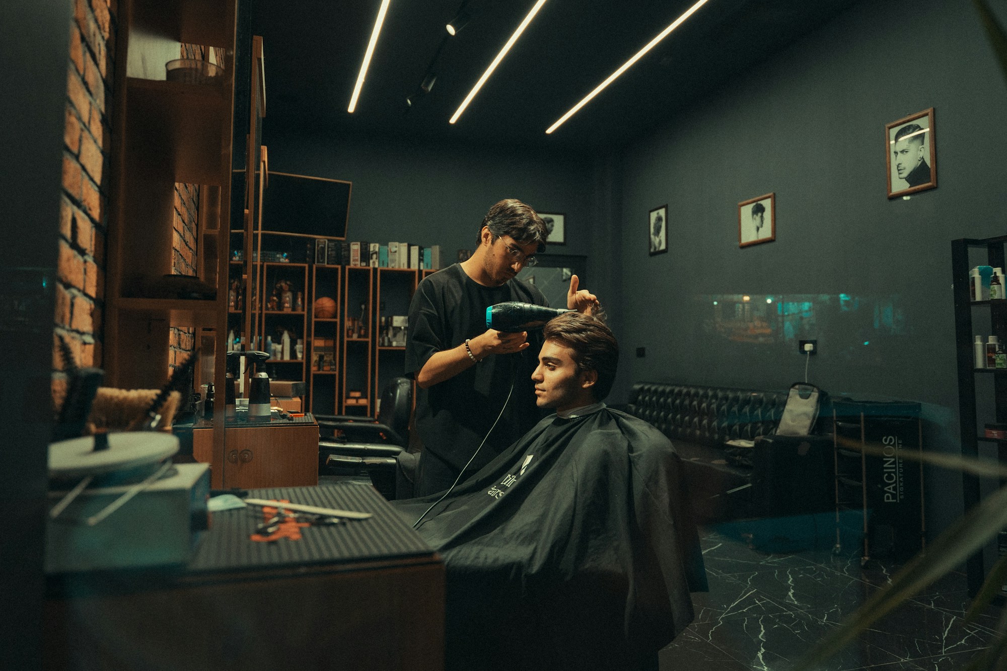 Un barber coupe les cheveux d'un client dans le salon