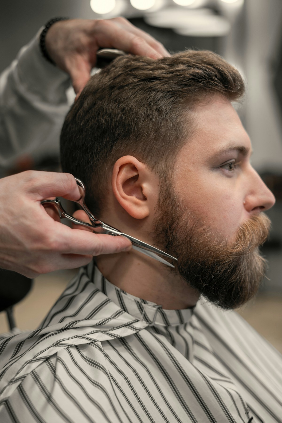Un barbier taille une barbe aux ciseaux