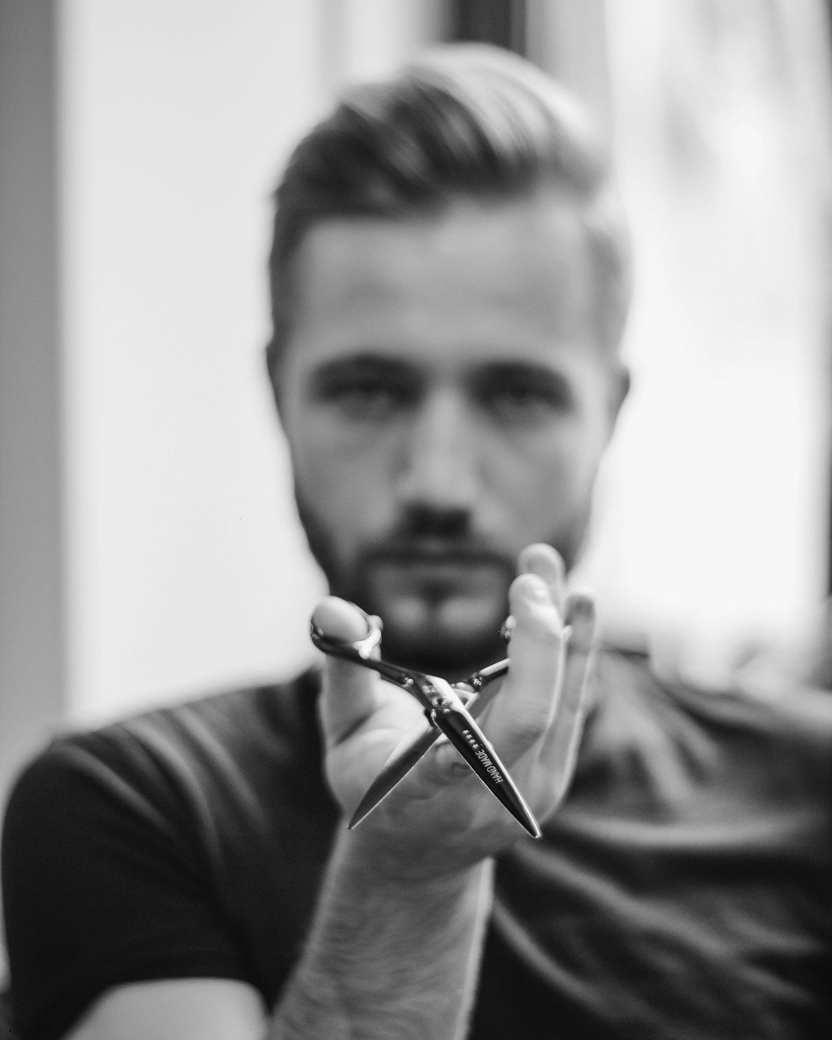 Portrait en noir et blanc d'un barbier tenant des ciseaux